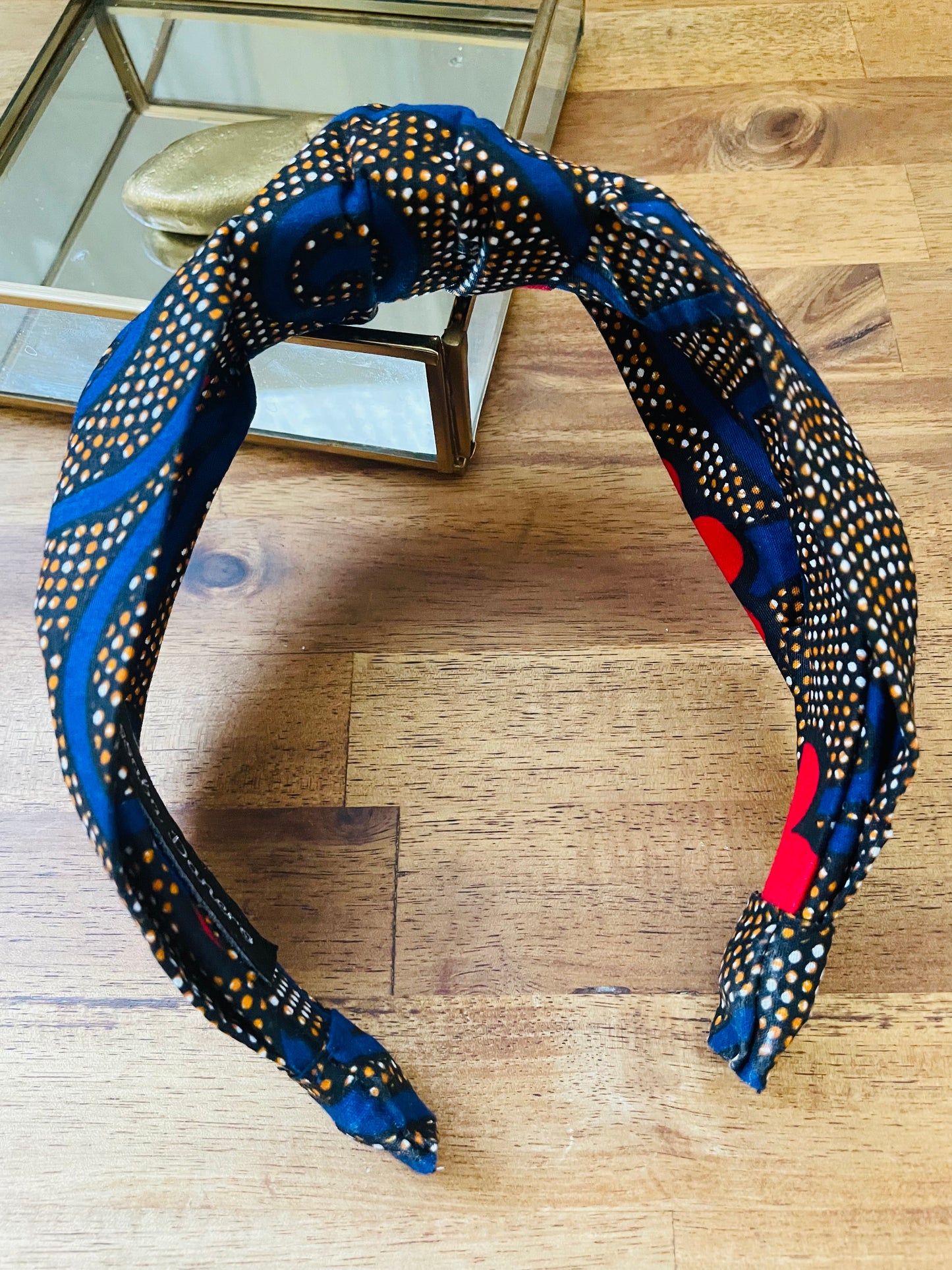 Serre-tête à nœud en wax "Spirales bleues et fleurs rouges"